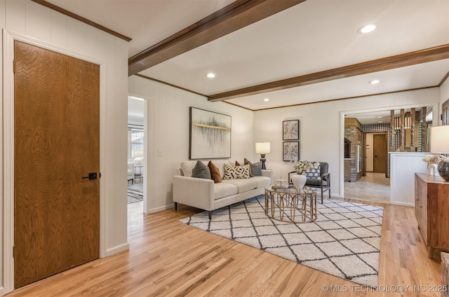 living room with ornamental molding, beam ceiling, baseboards, and light wood-style floors