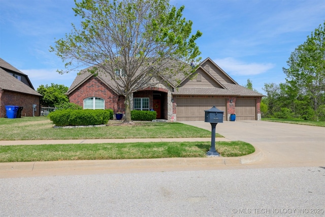 traditional-style house with brick siding, an attached garage, a front yard, and driveway