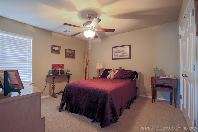 bedroom featuring visible vents, a ceiling fan, baseboards, and light carpet