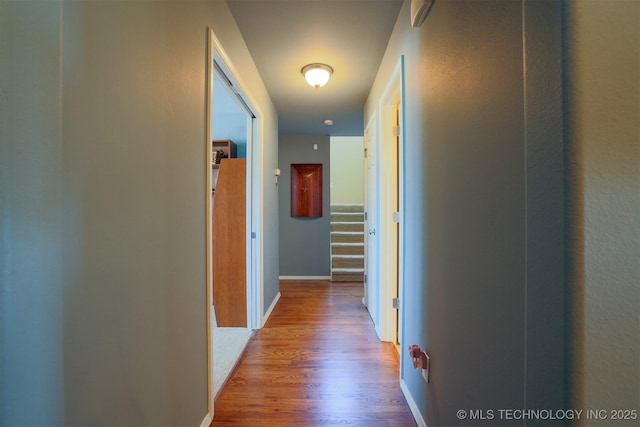 hallway featuring baseboards and wood finished floors