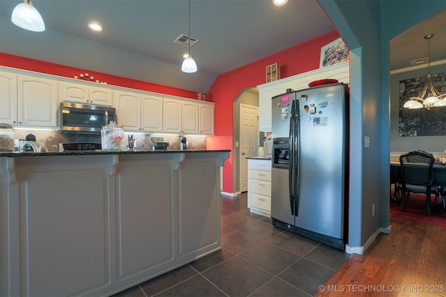 kitchen with white cabinets, arched walkways, stainless steel appliances, and visible vents