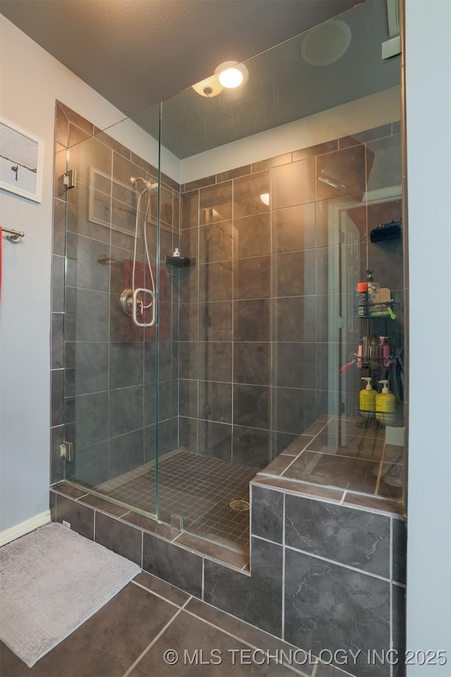 full bath with a shower stall and tile patterned floors