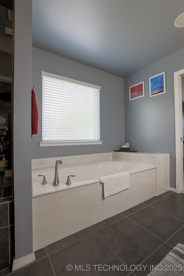 bathroom featuring a garden tub and tile patterned flooring