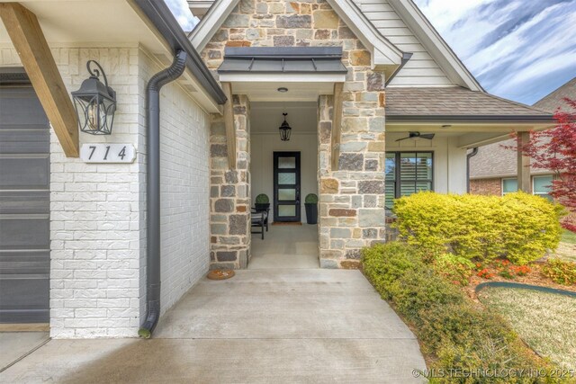 view of exterior entry featuring stone siding, brick siding, and a porch