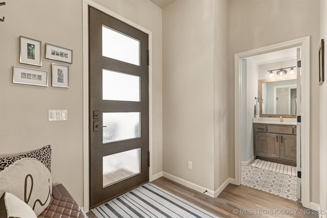 foyer entrance with wood finished floors, plenty of natural light, and baseboards