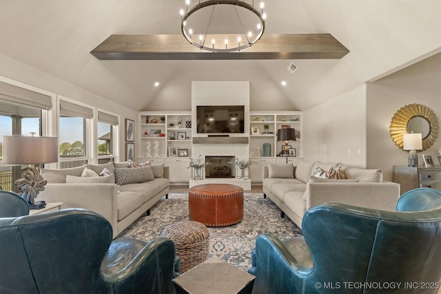 living room with a chandelier, a large fireplace, and built in shelves