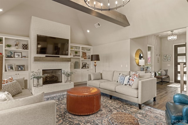 living area with high vaulted ceiling, a chandelier, wood finished floors, a brick fireplace, and beam ceiling