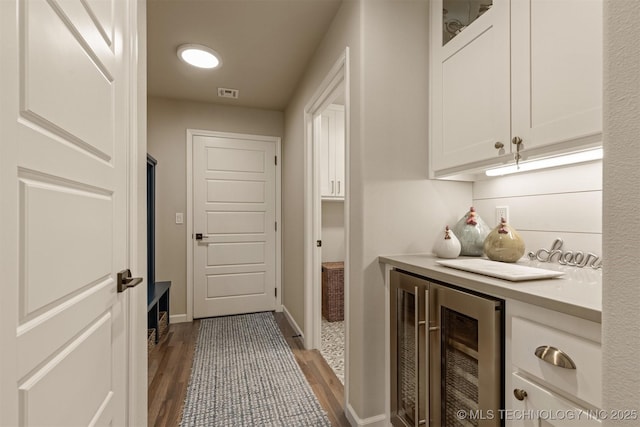 interior space with beverage cooler, dark wood finished floors, and baseboards