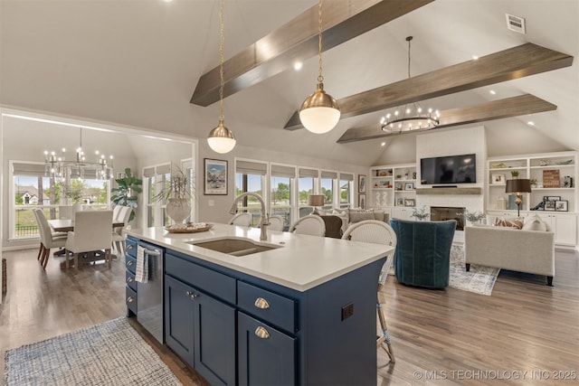 kitchen featuring a chandelier, a sink, stainless steel dishwasher, beam ceiling, and light countertops