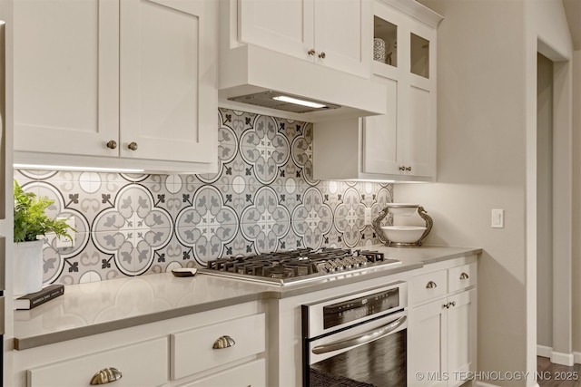 kitchen featuring appliances with stainless steel finishes, tasteful backsplash, light countertops, and white cabinetry