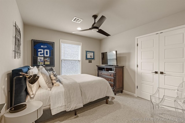 bedroom with light carpet, a ceiling fan, baseboards, and a closet