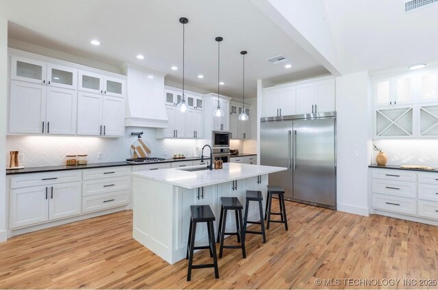 9520 N 144th Ave E, Owasso, OK 74055 - kitchen with built in appliances, a sink, backsplash, light wood finished floors, and recessed lighting