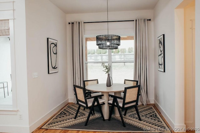 9520 N 144th Ave E, Owasso, OK 74055 - dining space with baseboards, a chandelier, and wood finished floors