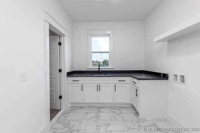 9520 N 144th Ave E, Owasso, OK 74055 - clothes washing area with washer hookup, light marble finish flooring, baseboards, and cabinet space