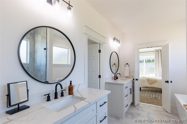 9520 N 144th Ave E, Owasso, OK 74055 - full bathroom with marble finish flooring, two vanities, connected bathroom, and a tub