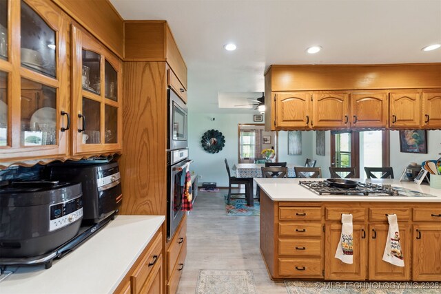 10495 S 426th Rd, Inola, OK 74036 - kitchen with stainless steel appliances, light countertops, recessed lighting, brown cabinets, and glass insert cabinets