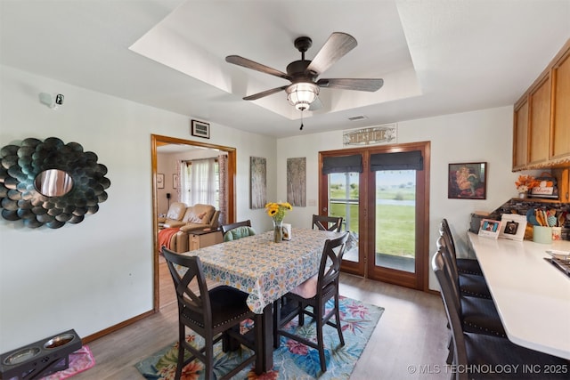 10495 S 426th Rd, Inola, OK 74036 - dining space featuring light wood-style flooring, a tray ceiling, and a ceiling fan