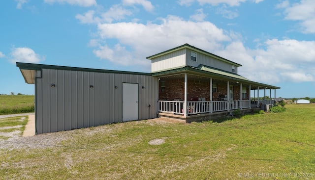 10495 S 426th Rd, Inola, OK 74036 - view of home's exterior with a lawn, a porch, brick siding, and an outdoor structure