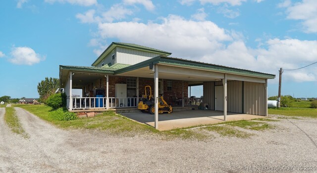 10495 S 426th Rd, Inola, OK 74036 - farmhouse with dirt driveway, brick siding, covered porch, and a carport