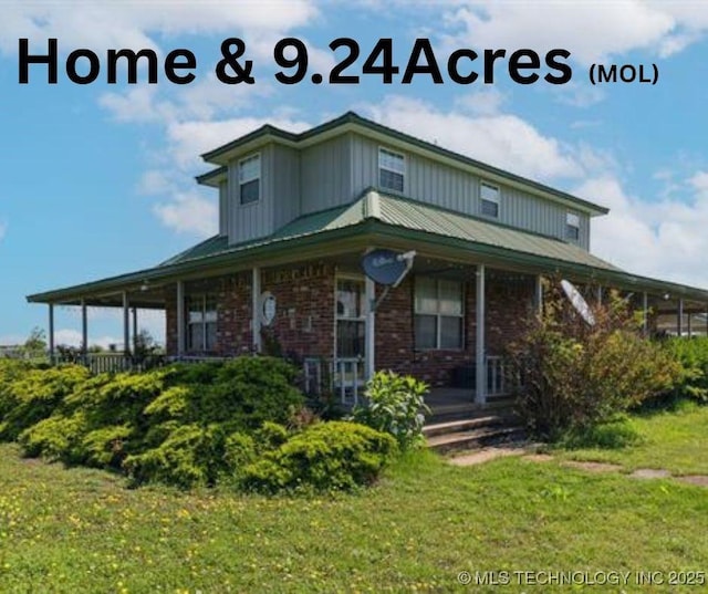 10495 S 426th Rd, Inola, OK 74036 - view of front of home featuring covered porch, brick siding, board and batten siding, and a front lawn