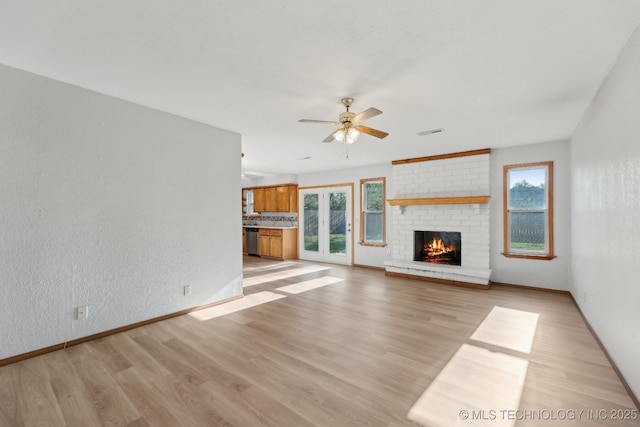 13973 S Hickory St, Glenpool, OK 74033 - unfurnished living room featuring a ceiling fan, light wood finished floors, a fireplace, baseboards, and visible vents