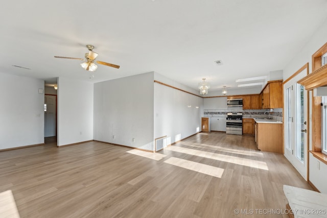 13973 S Hickory St, Glenpool, OK 74033 - unfurnished living room featuring light wood-type flooring, baseboards, and ceiling fan with notable chandelier