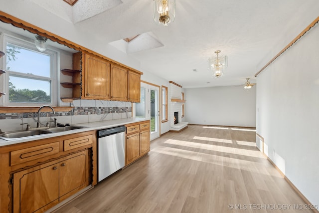 13973 S Hickory St, Glenpool, OK 74033 - kitchen featuring light countertops, dishwasher, a sink, a skylight, and light wood-style flooring