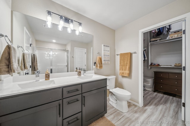 13010 E 125th Pl N, Collinsville, OK 74021 - full bathroom featuring double vanity, a stall shower, wood finished floors, and a closet