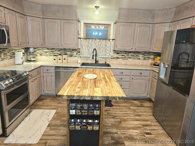 kitchen featuring a sink, dark wood-style flooring, decorative backsplash, butcher block counters, and appliances with stainless steel finishes