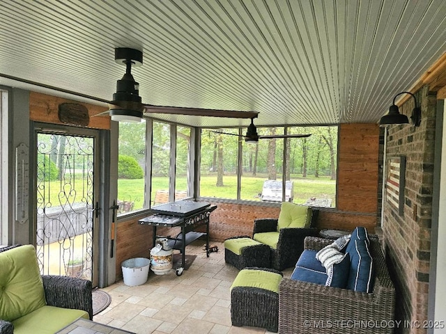 sunroom with plenty of natural light, a ceiling fan, and an outdoor living space
