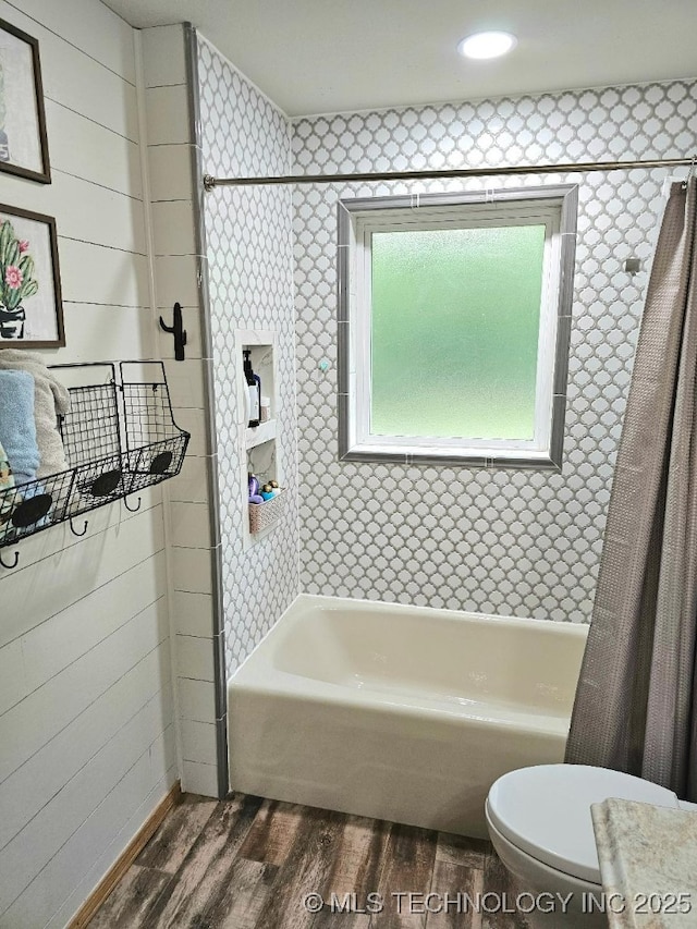 full bath featuring shower / tub combo, wood finished floors, and toilet