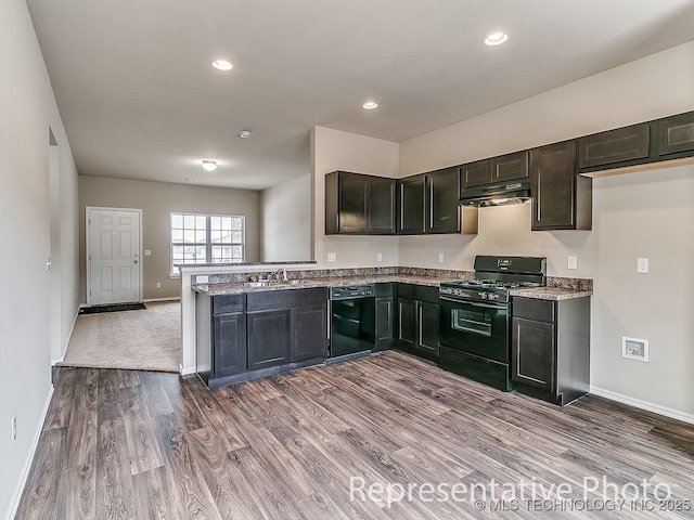 8411 E Queens Pl, Broken Arrow, OK 74014 - kitchen featuring under cabinet range hood, wood finished floors, baseboards, black appliances, and a peninsula