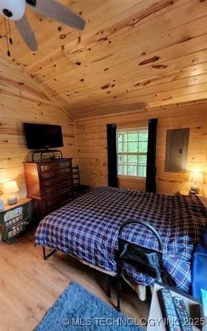 bedroom with wood walls and wood finished floors