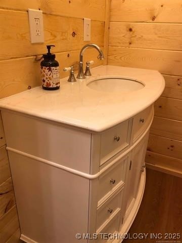 bathroom with wood walls and vanity