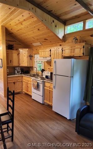 kitchen with a sink, dark wood finished floors, wooden ceiling, and white appliances