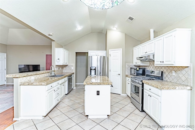 kitchen with a sink, appliances with stainless steel finishes, a peninsula, under cabinet range hood, and visible vents
