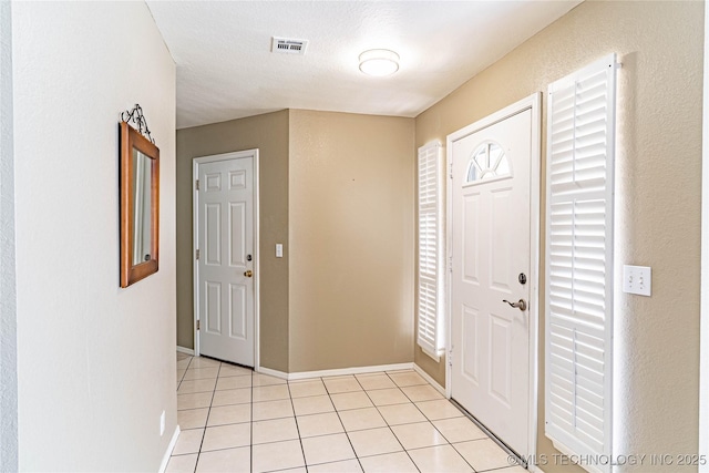 entrance foyer with baseboards, visible vents, and light tile patterned floors