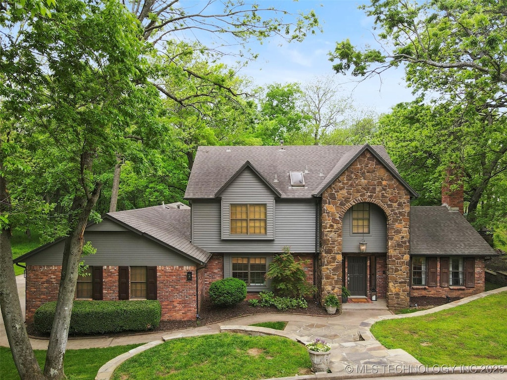 9202 N 182nd E Ave, Owasso, OK 74055 - view of front of home featuring a shingled roof, a front yard, and brick siding