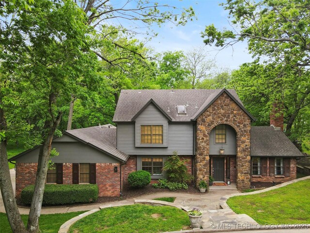 9202 N 182nd E Ave, Owasso, OK 74055 - view of front of home featuring a shingled roof, a front yard, and brick siding