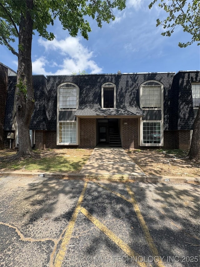 6816 S Toledo Ave Unit 316, Tulsa, OK 74136 - front facade with a shingled roof, uncovered parking, and brick siding