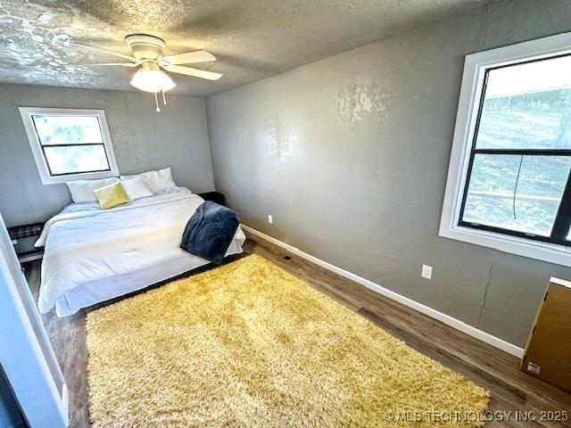 19690 W 892nd Rd, Park Hill, OK 74451 - bedroom featuring wood finished floors, a textured ceiling, and a ceiling fan