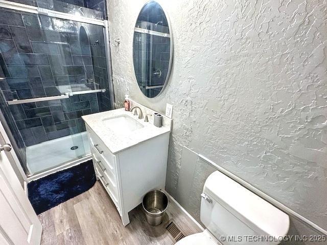 19690 W 892nd Rd, Park Hill, OK 74451 - full bathroom featuring a textured wall, vanity, wood finished floors, and a stall shower