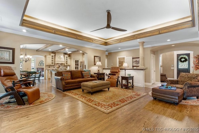 living room featuring crown molding, arched walkways, recessed lighting, wood finished floors, and a ceiling fan