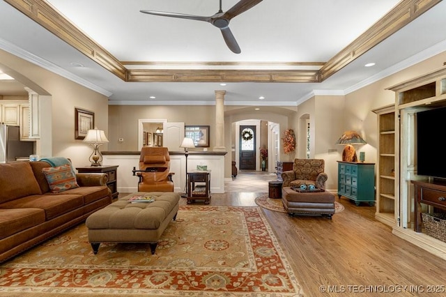 living area with light wood finished floors, arched walkways, and a ceiling fan