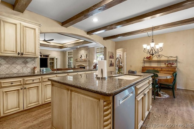 kitchen featuring a sink, wood finished floors, stainless steel dishwasher, and arched walkways