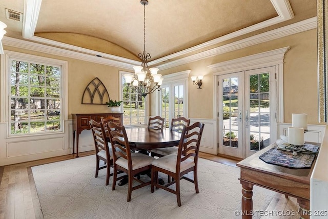 dining room with ornamental molding, visible vents, french doors, and light wood-style floors