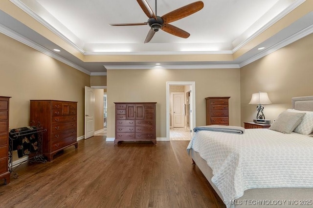 bedroom with recessed lighting, wood finished floors, baseboards, crown molding, and a tray ceiling