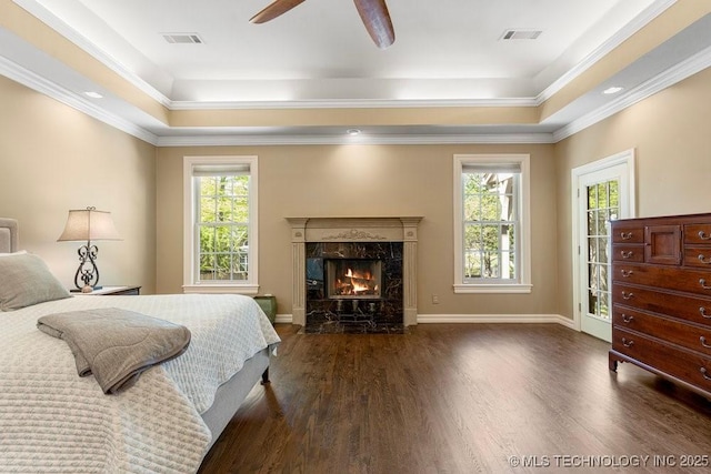 bedroom with a fireplace, wood finished floors, crown molding, and visible vents