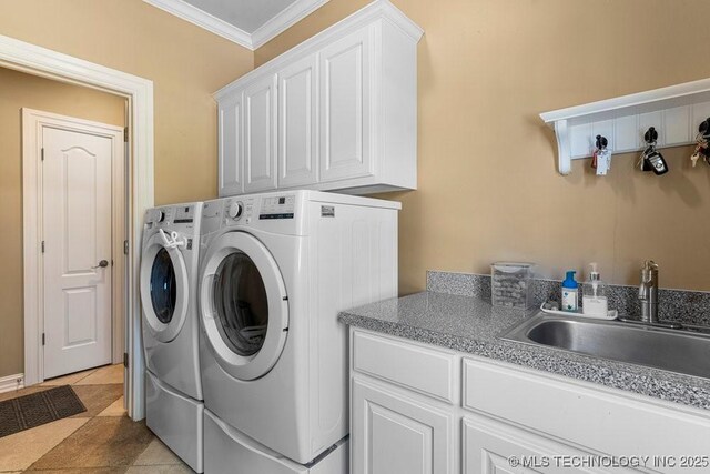 washroom with washer and dryer, crown molding, cabinet space, and a sink