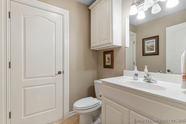 bathroom featuring vanity, toilet, and tile patterned flooring